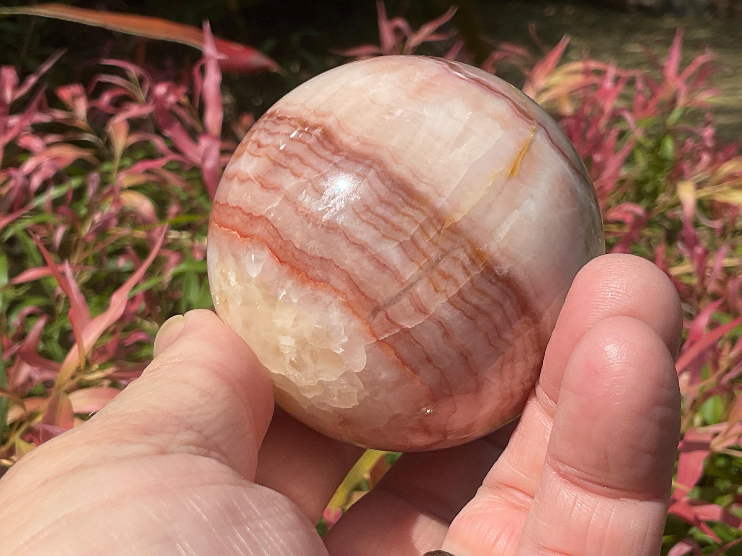 369g (5.9cm diameter) Red Banded Calcite Sphere A