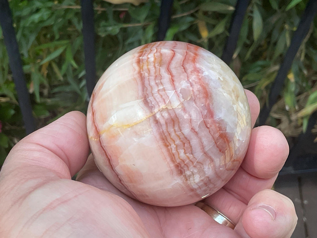 369g (5.9cm diameter) Red Banded Calcite Sphere A