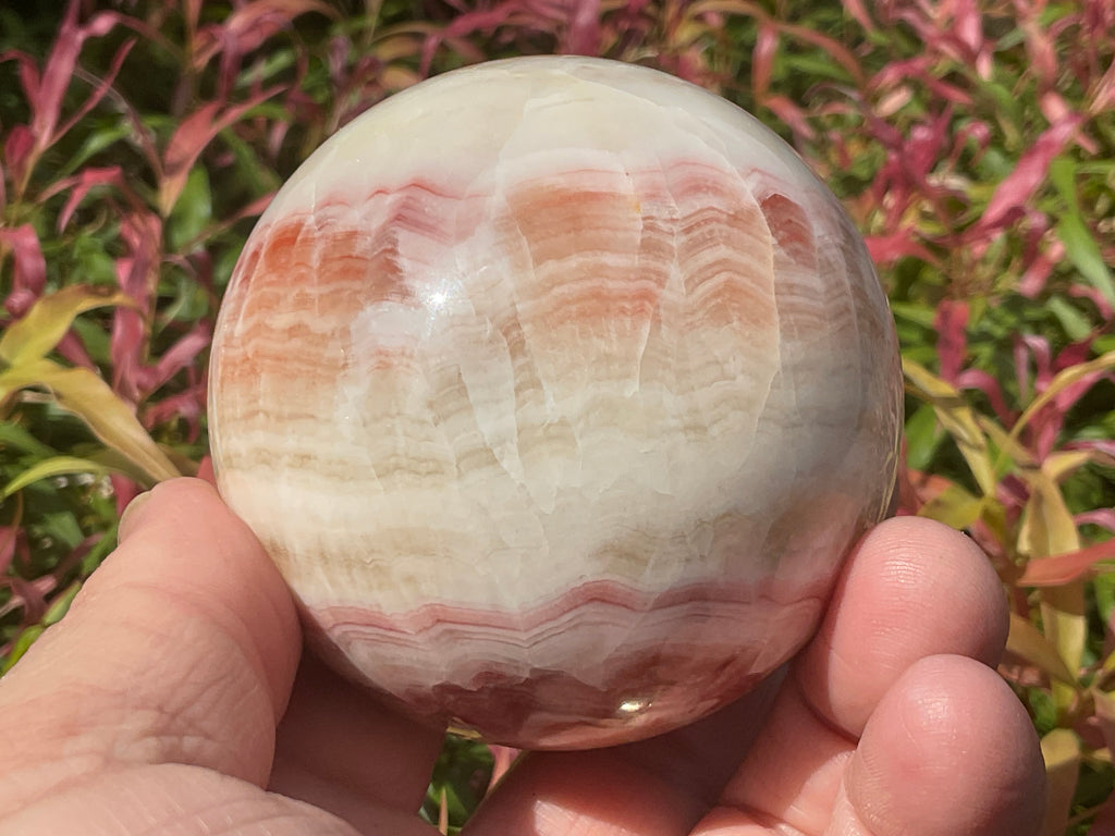 452g (6.3cm diameter) Red Banded Calcite Sphere C