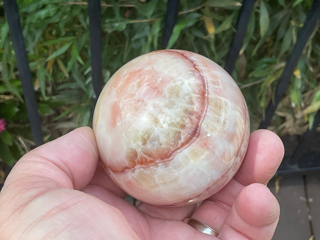 369g (5.9cm diameter) Red Banded Calcite Sphere A