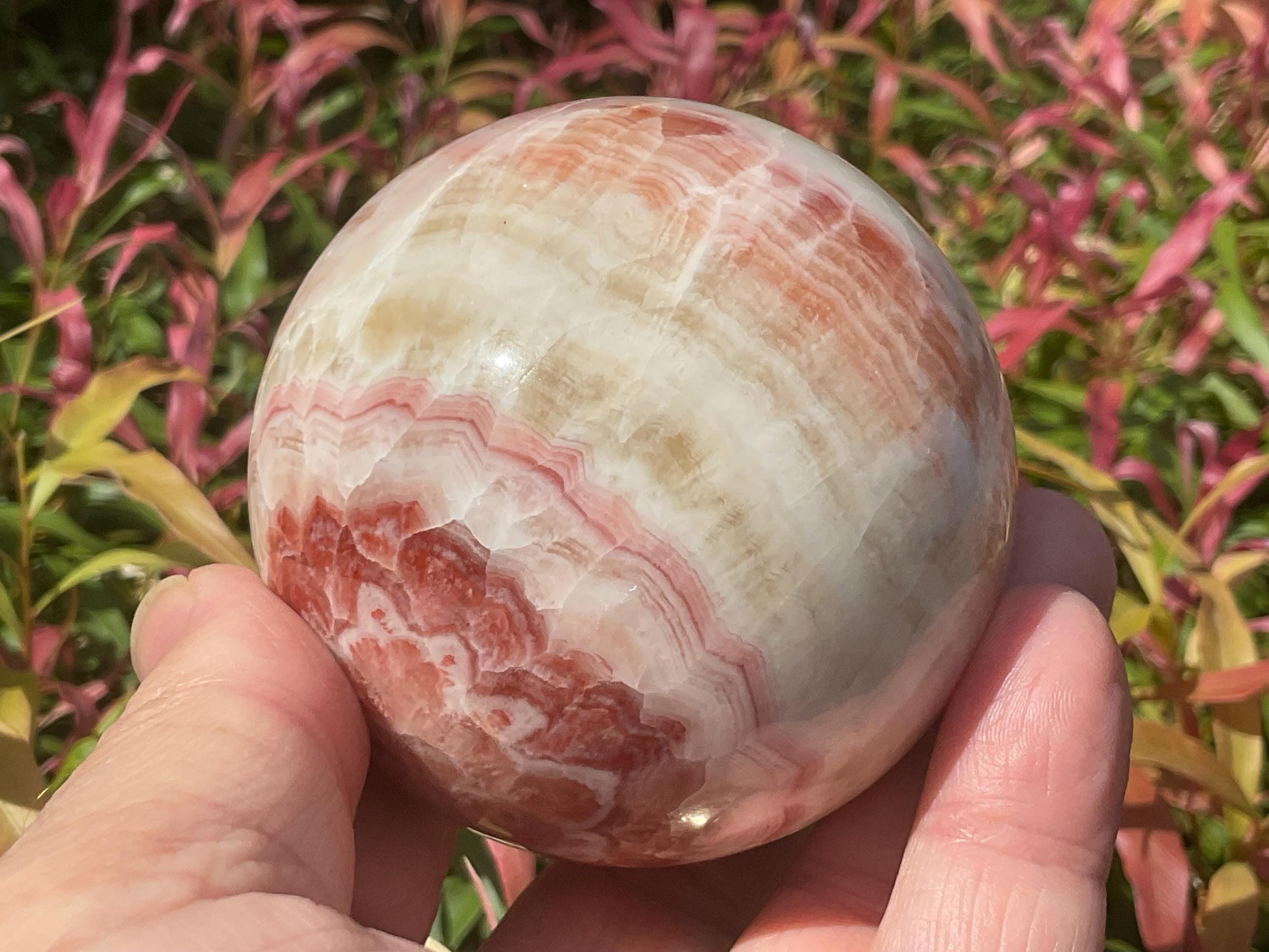 452g (6.3cm diameter) Red Banded Calcite Sphere C